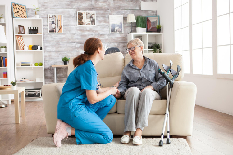 A home care professional sharing a warm conversation with an older woman